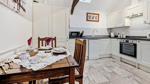 A dining area with a table set for four, a kitchen with modern appliances, and a skylight. - 1 bedroom accommodation in South Barrow, near Yeovil (South Barrow, near Yeovil)