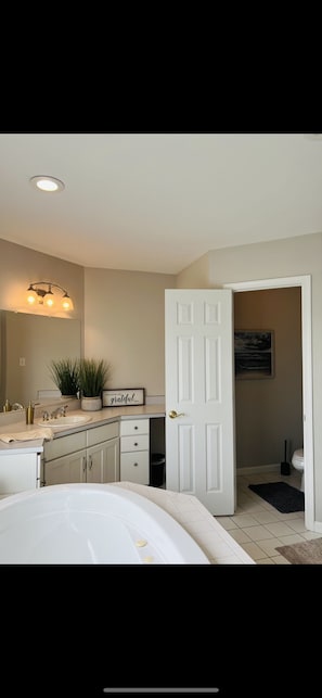 A bedroom with a white door, a large window, and a bedside table with a lamp. - Stunning Views, Sleeps 20, Pool, Hot Tub, 7 bedrooms (York)