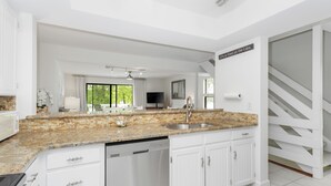A modern kitchen with white cabinetry, a granite countertop, and a dishwasher. - Lakefront Retreat at Smith Mountain Lake. Covered Boat Slip + Kayaks (Moneta)