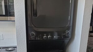 Ett kompakt kök med mikrovågsugn, spishäll och ugn.