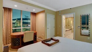 A hotel room with a large bed, a desk, a window with a city view, and a bathroom visible through an open door. - MGM Signature 1BR 2BA Wet Republic, Top Golf & Strip Views / NO Resort Fee (Las Vegas)