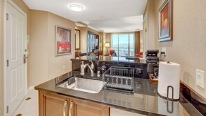 A modern kitchen with a sink, dish rack, and countertop. - MGM Signature 1BR 2BA Wet Republic, Top Golf & Strip Views / NO Resort Fee (Las Vegas)