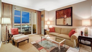 A hotel room with a large window, a sofa, a coffee table, and a painting on the wall. - MGM Signature 1BR 2BA Wet Republic, Top Golf & Strip Views / NO Resort Fee (Las Vegas)