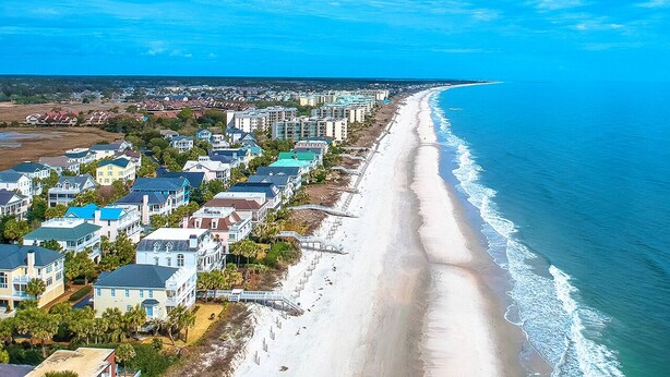 A coastal residential area with beachfront properties and a long sandy beach. - Beautiful 2 bed 2 bath Corner Unit with golf course view-5 minutes from beach (Pawleys Island)
