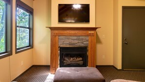 A room with a fireplace, a television mounted above it, and a door to the right. - Wisconsin Dells | Pool & Waterpark Access | 3BR Townhome  Sleeps 8 (Wisonsin Dells)