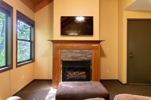A room with a fireplace, a television mounted above it, and a door to the right. - Wisconsin Dells | Pool & Waterpark Access | 3BR Townhome  Sleeps 8 (Wisonsin Dells)