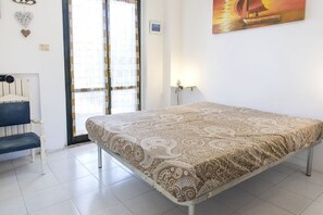 A bedroom with a bed, a bench, a wall clock, and a painting. - M323 - Marcelli, delightful three-room apartment with garden (Marcelli)