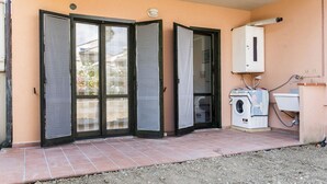 Un'area esterna riparata con lavatrice e un armadietto di servizio.