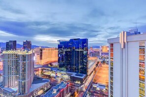A cityscape with high-rise buildings, including a prominent hotel with a modern design and a view of the surrounding urban area. - MGM 37th floor Jacuzzi Penthouse Strip View with XL Balcony Signature Towers (Las Vegas)