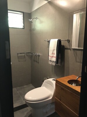 Een douche, handdoeken, zeep, toiletpapier