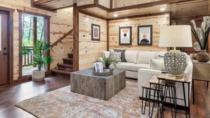 A wooden interior with a sofa, coffee table, and lamp. - Giant Luxury 10BR Cabin Huge Outdoor Area, Pool (Sevierville)