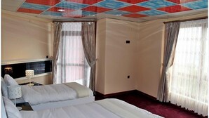 A hotel room with a large bed, a flat-screen TV, and two windows with curtains. - Konerkon Otel Plaza (Ermenek)