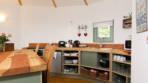 Una cucina compatta con mobili in legno, lavello incassato e forno a microonde.