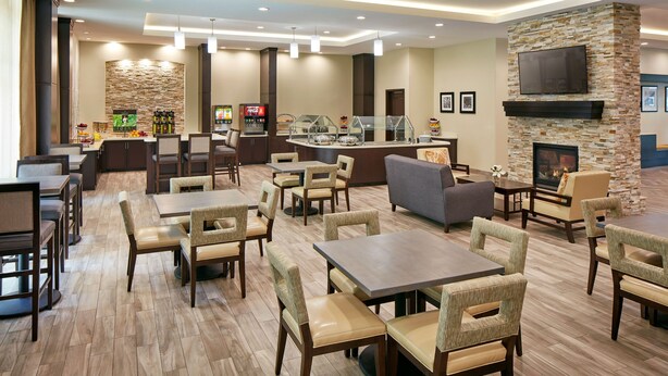 A hotel lobby with multiple seating areas, a bar, and a fireplace. - Queen Studio Suite w/ Kitchen Near Disney (Anaheim)