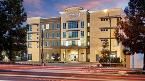 A Staybridge Suites hotel with a modern design, multiple floors, and a well-lit entrance. - Queen Studio Suite w/ Kitchen Near Disney (Anaheim)