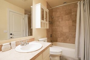 Une salle de bain équipée d’un lavabo, de toilettes, d’une baignoire et d’une douche.