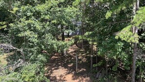 A wooden bridge leading to a forested area with a dirt path. - Beautiful Lake Lanier Home, 2 story dock, Paddle Boards, & Pedle Boat (Dawsonville)