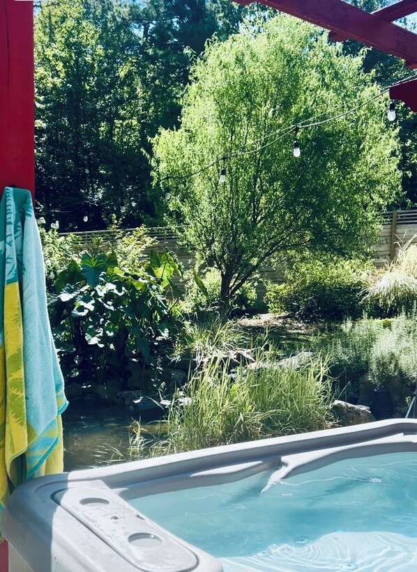 A hot tub with a view of a pond and trees.