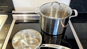 A kitchen with a stove, two pots, and a kettle. - Polynesian Koi Pond Gardens Condo in Hilo w pool (Hilo)