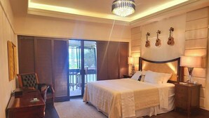 A bedroom with a bed, bedside tables, a desk, and a chandelier. - Polynesian Koi Pond Gardens Condo in Hilo w pool (Hilo)