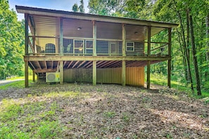 A two-story wooden cabin with a balcony, surrounded by a forest. - Peaceful Decatur Cabin w/ Grill & Fire Pit! (Decatur)