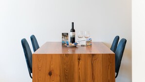 A wooden table with a bottle of wine, two glasses, and a welcome sign. - GuestReady - Mompilher Apartments (Porto)