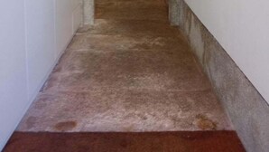 Ein schmaler Flur mit einem roten Sofa am Ende, der zu einem Raum führt.