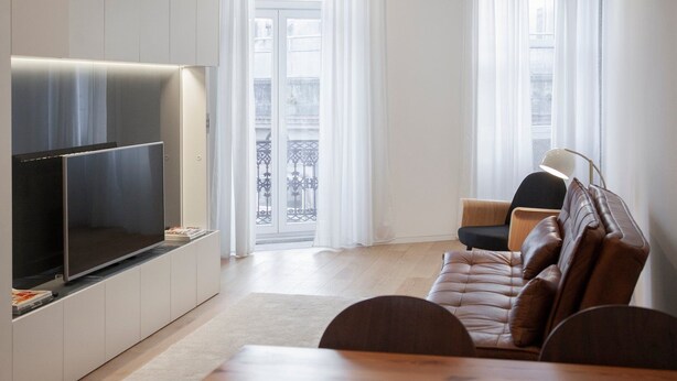 A modern living room with a flat-screen TV, a leather sofa, a wooden coffee table, and a floor lamp. - GuestReady - Mompilher Apartments (Porto)