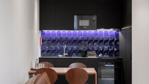 A modern kitchen with a black microwave, a sink, and a coffee maker on the counter. - GuestReady - Mompilher Apartments (Porto)
