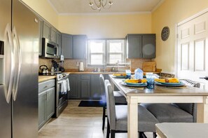 Enjoy cooking in this well-equipped kitchen with a refrigerator, microwave, and oven, and dine at the adjacent table.