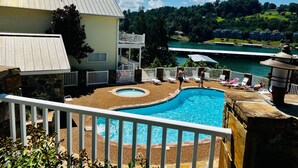 A swimming pool with a view of a lake and a two-story building with a balcony. - Waterfront 5 Bed, 4 bath w/Golf, Winery, Tiki bar, Deerfield Marina, & boat slip (La Follette)