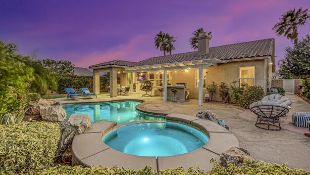 A backyard with a swimming pool, lounge chairs, and a covered patio area. - Feel yourself at home !!! (Indio)