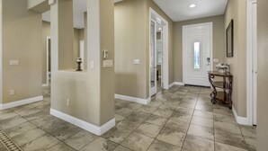 A spacious hallway with beige walls, white trim, and a tiled floor. - Feel yourself at home !!! (Indio)