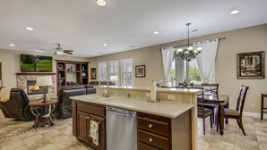 A spacious living room with a fireplace, a dining area, and a kitchen with a dishwasher. - Feel yourself at home !!! (Indio)