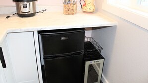 Una cocina compacta con nevera integrada, horno pequeño y microondas.