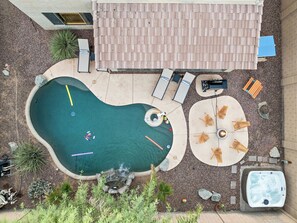 A swimming pool with a hot tub, lounge chairs, and a fire pit area. - Desert Oasis Amazing Pool/Waterfall/Firepit/Office (Casa Grande)
