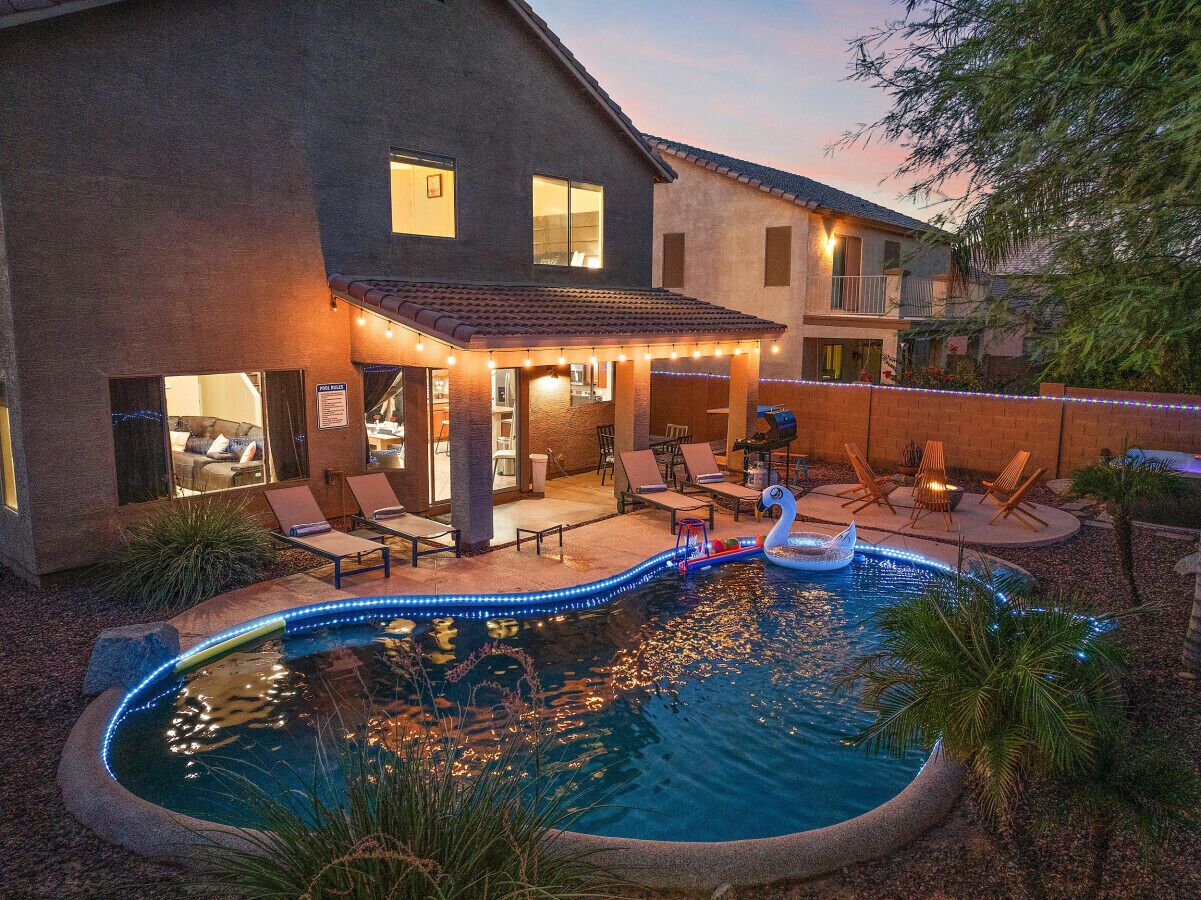 A swimming pool with a swan float, surrounded by lounge chairs and a covered patio area.