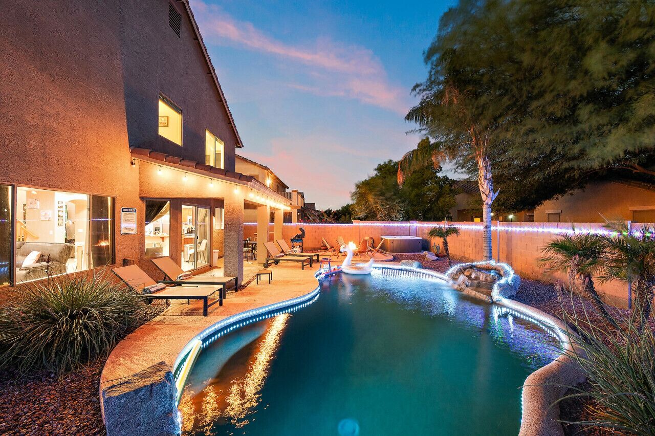 A pool area with lounge chairs and a water feature.