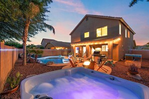 Een huis met een zwembad, buitenzitplaatsen en een jacuzzi.