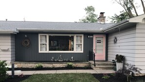 A house with a dark gray exterior, a pink door, and a white window frame. - RENTAL - 4.7 miles away, newly remodeled ranch home (Oshkosh)