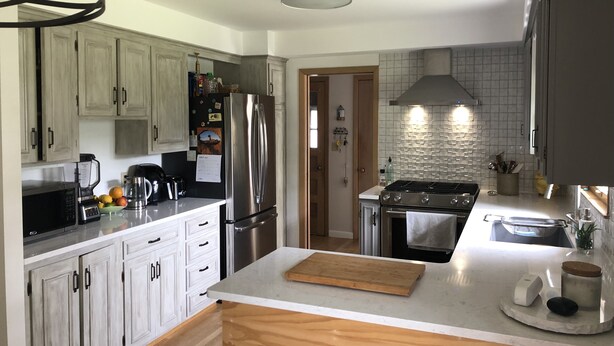 A modern kitchen with light wood cabinets, stainless steel appliances, and a white countertop. - RENTAL - 4.7 miles away, newly remodeled ranch home (Oshkosh)