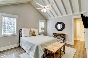 A bedroom with a bed, a ceiling fan, a bedside table with a lamp, a chair, and a mirror on the wall. - 7 Seaside Sparrow at The Sea Pines Resort (Hilton Head Island)