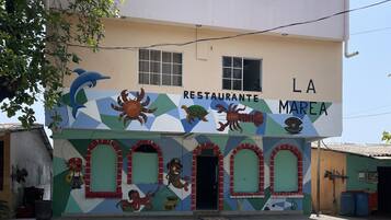 Un edificio con un mural colorido que muestra criaturas marinas y el texto