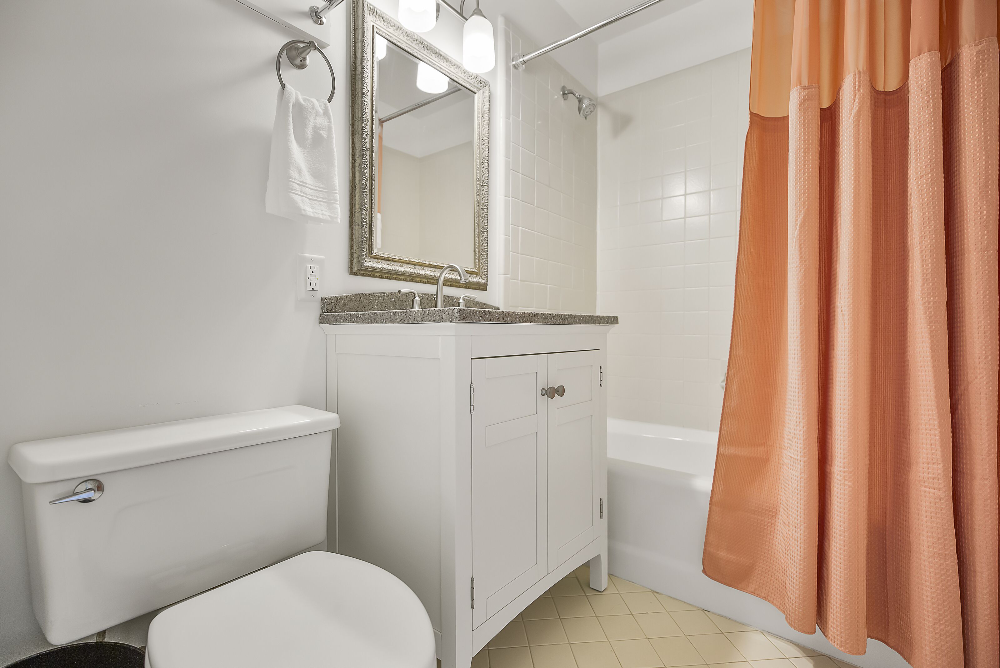 A bathroom with a toilet, sink, mirror, and shower curtain.