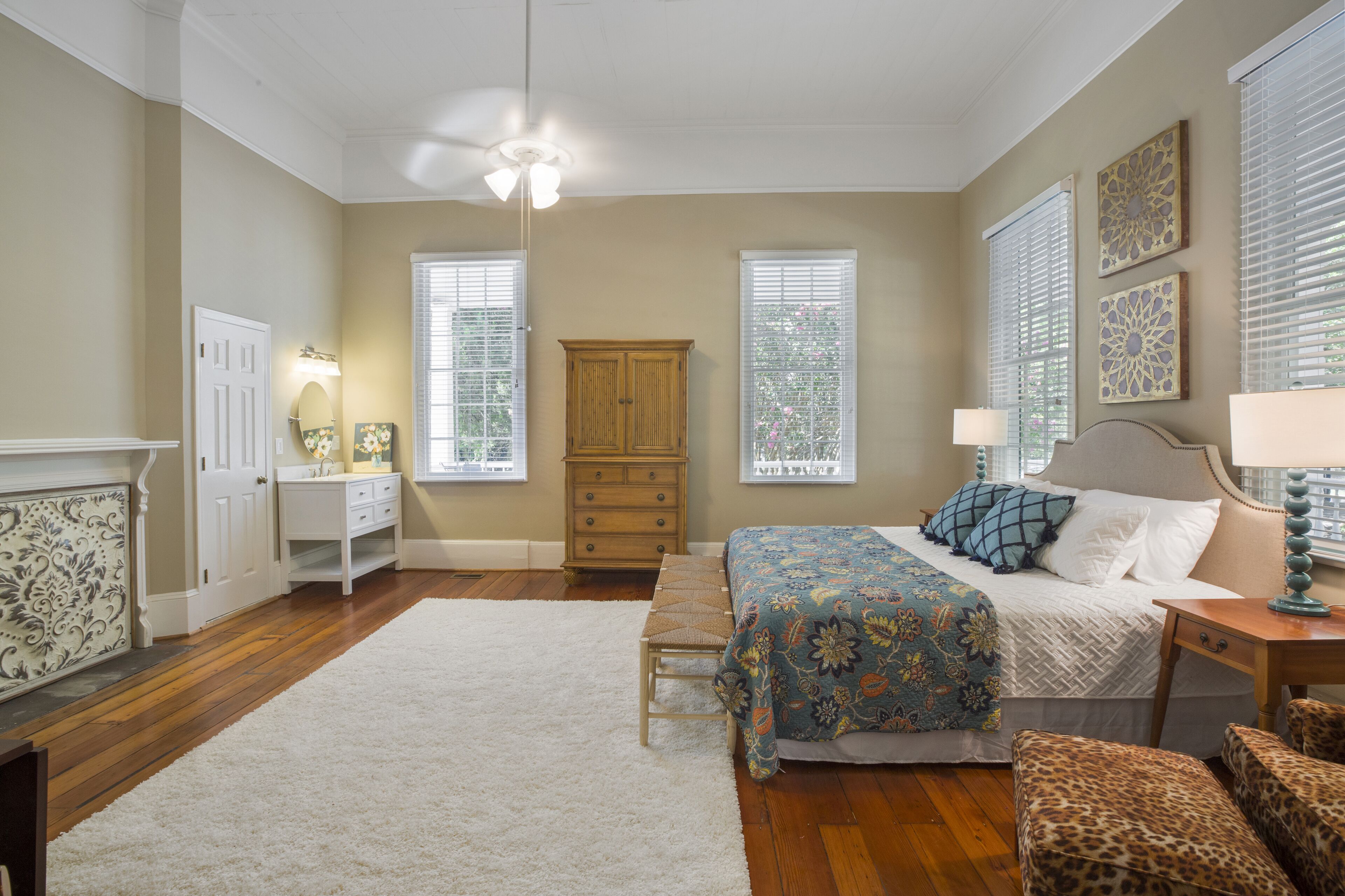A bedroom with a bed, a dresser, a bench, and a cabinet.