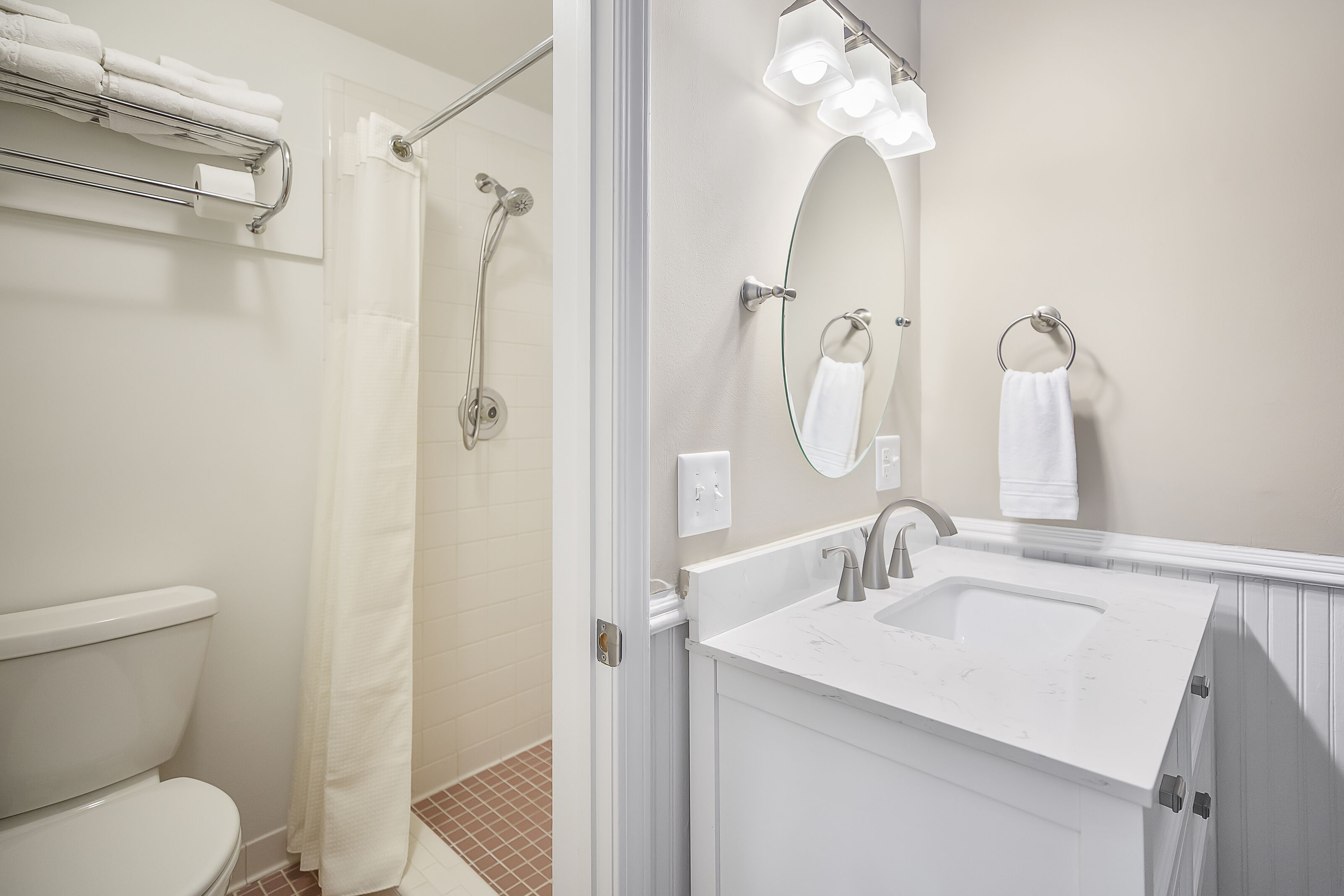 A modern bathroom with a toilet, shower, and sink.