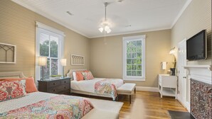 A bedroom with two beds, a TV, and a fireplace. - Liberty Hall Bed and Breakfast (Pendleton)