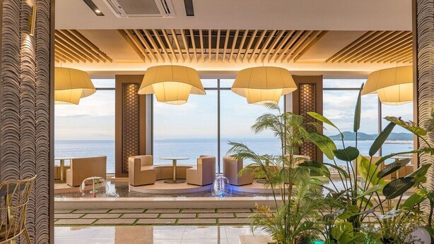 A modern indoor pool area with seating and large windows overlooking the sea. - Yeonhwamoon Hotel Yeongdeok (Yeongdeok)