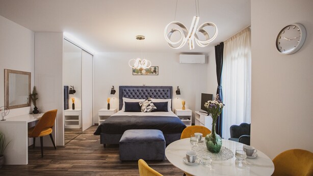 Una habitación de hotel moderna con una cama grande, un escritorio, un comedor y una sala de estar.