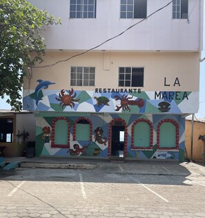 Um edifício com um mural de criaturas marinhas e a inscrição 